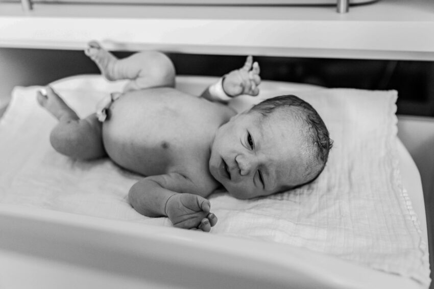 Geboortefotografie in Rotterdam, een bevalling in het Maasstad ziekenhuis, baby wordt nagekeken.