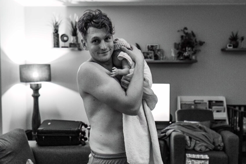trotse vader houdt voor het eerst zijn dochter vast bij een thuisbevalling in Heemskerk.