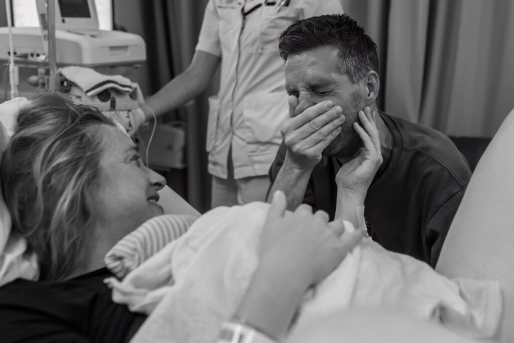 Echte momenten tijdens geboortefotografie - vader reageert emotioneel bij de geboorte van zijn dochter